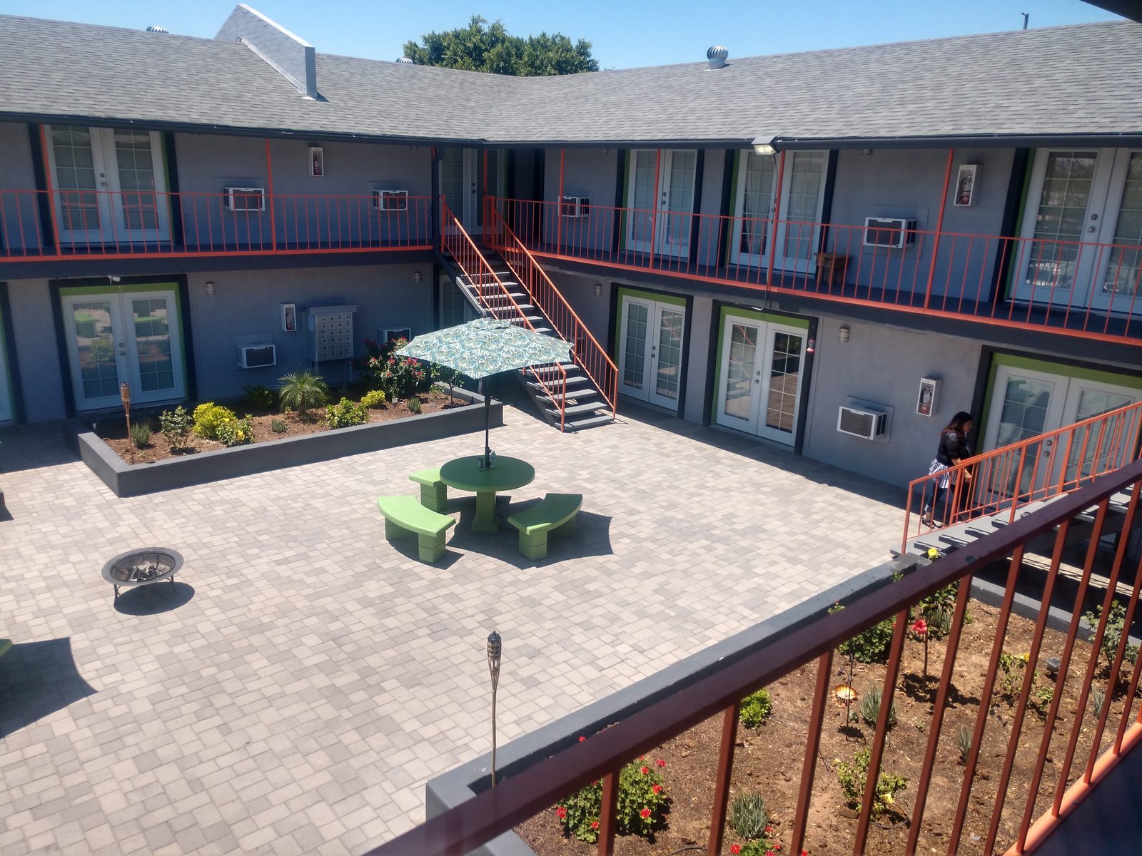 Courtyard view from balcony with fire pit and green picnic table at pet-friendly Phoenix studio apartments