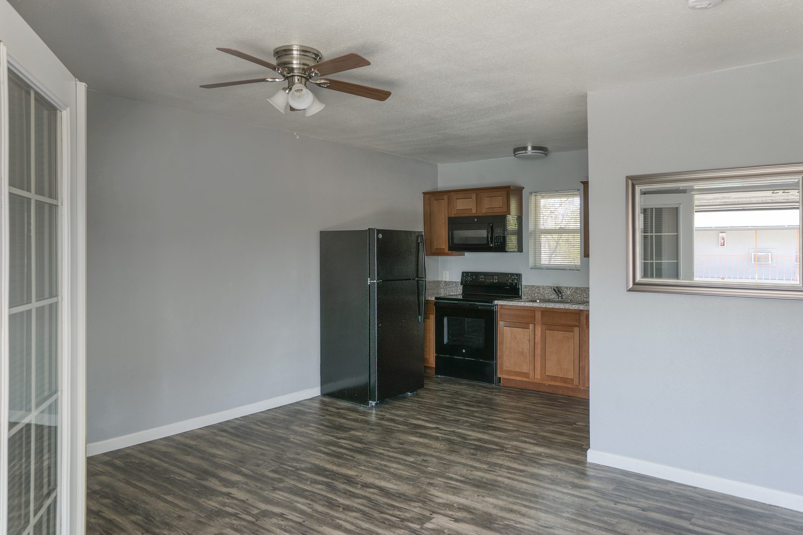 Open studio living area with full kitchen, ceiling fan, and french doors at Lucky Star Flats Phoenix